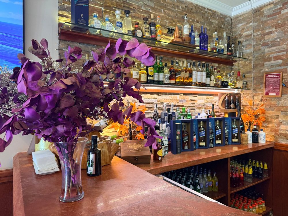 Barra de El Rececho con eucalipto morado y botellas al fondo