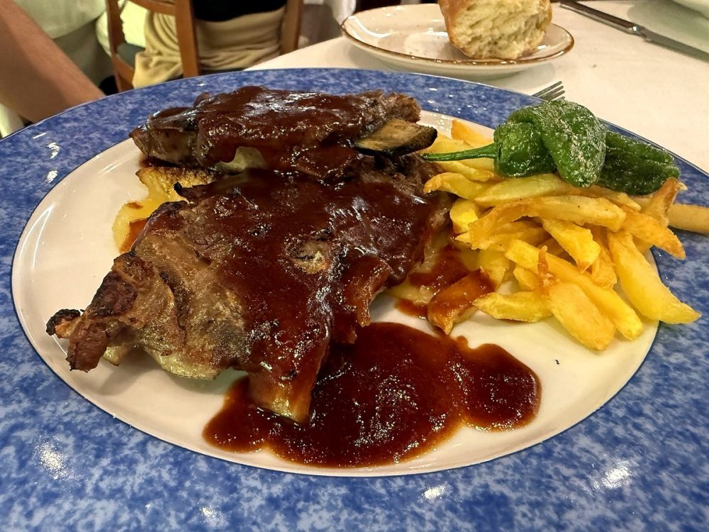Costillas con salsa barbacoa, patatas fritas y pimientos de Padrón