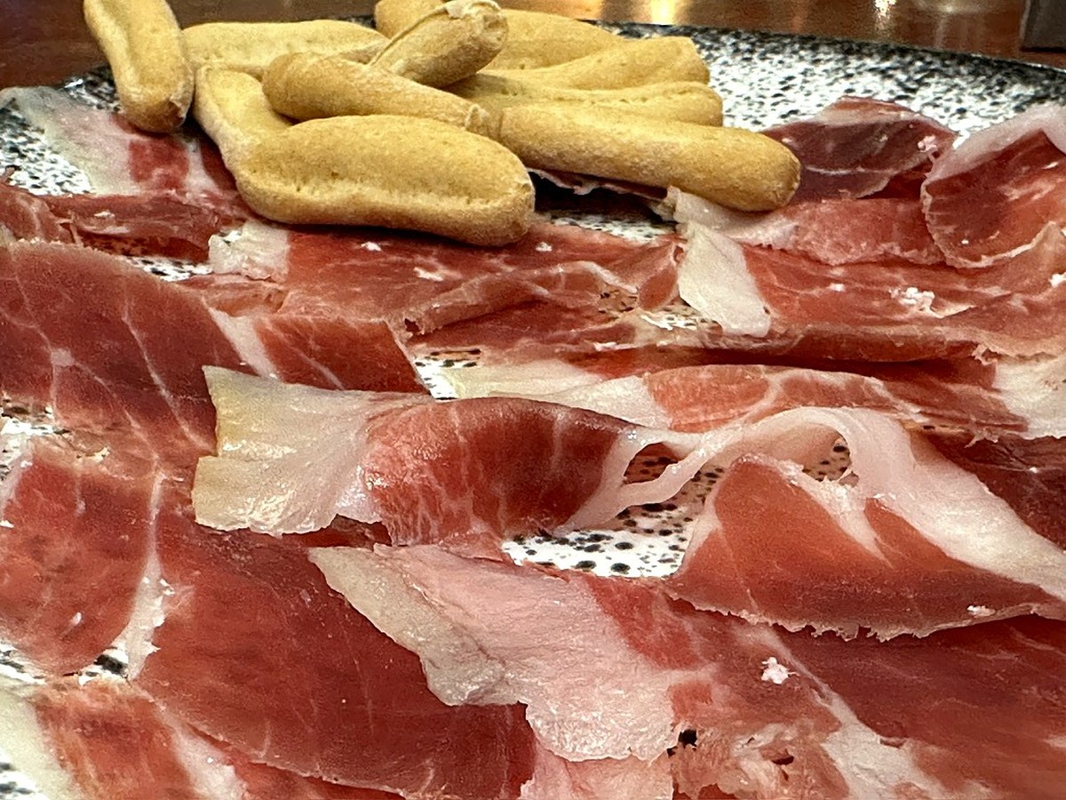 Jamón ibérico de bellota cortado a cuchillo con picos de pan, en El Rececho