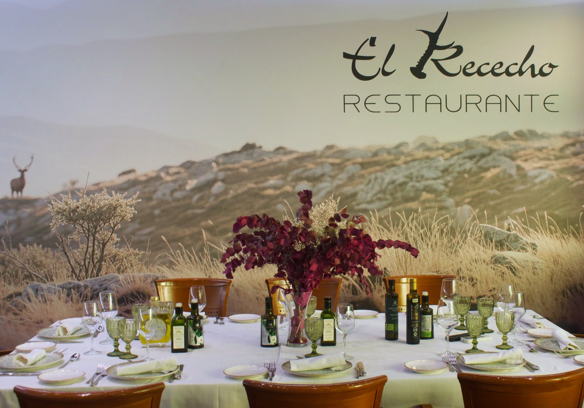 Comedor de El Rececho con la mesa puesta frente al mural de la sierra