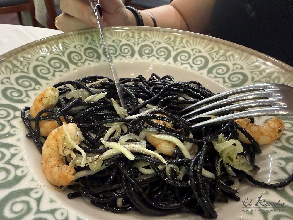 Detalle de espaguetis negros con gambas y tiras de calamar