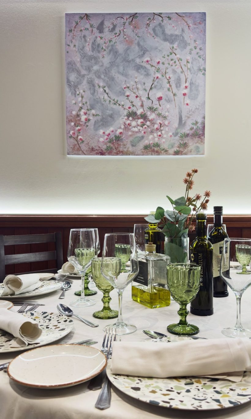 Mesa montada en El Rececho bajo un cuadro de flores de cerezo